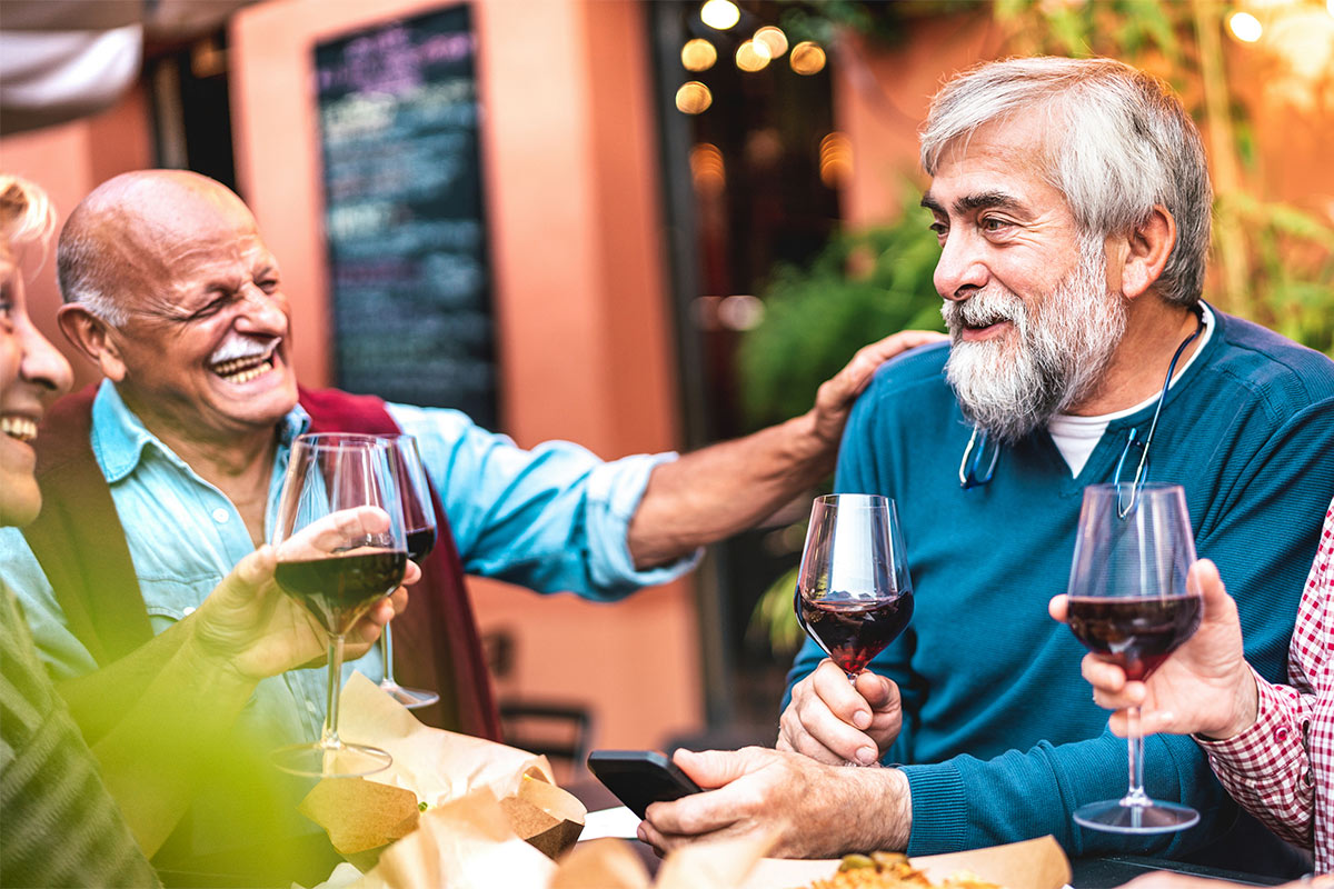 senior friends drinking wine together at a restaurant retirement planning tallahassee fl